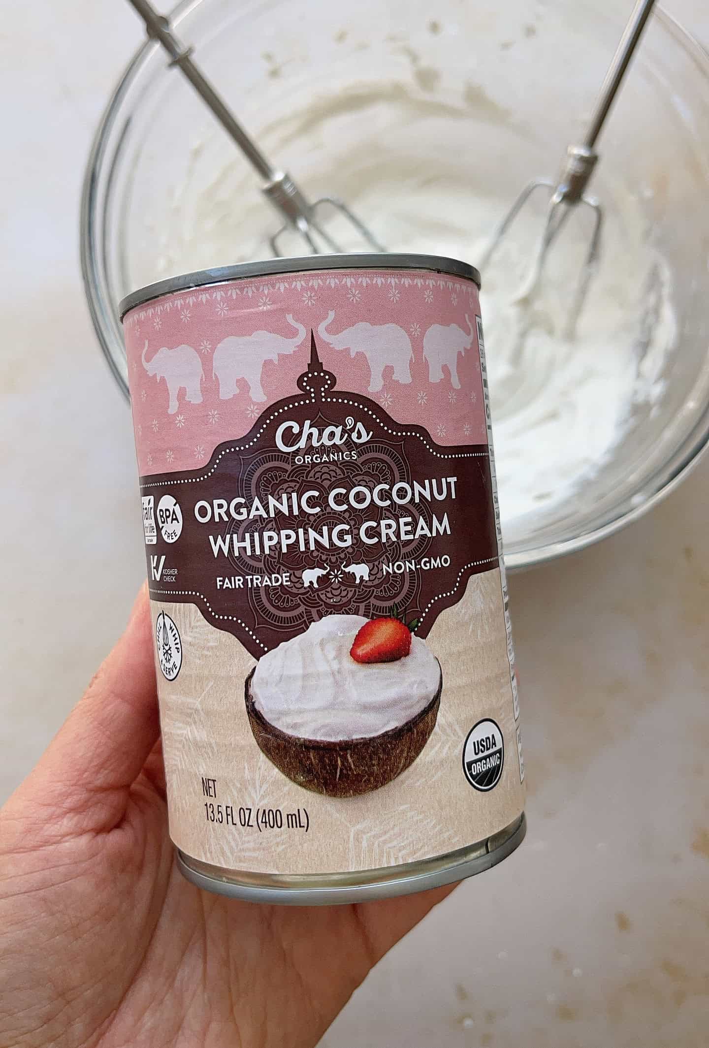 a hand holding a can of coconut whipping cream