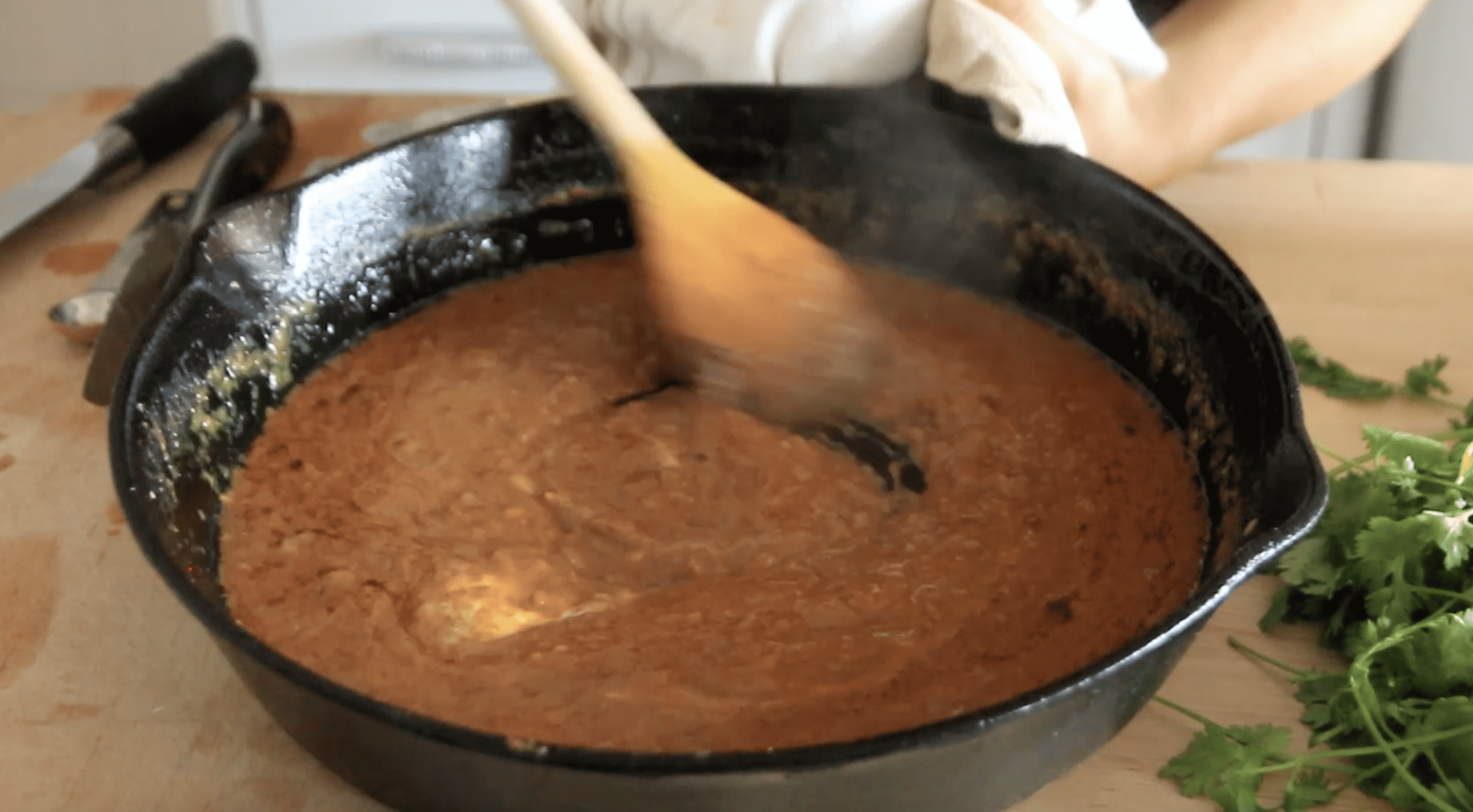 pan with a spoon stirring butter into sauce