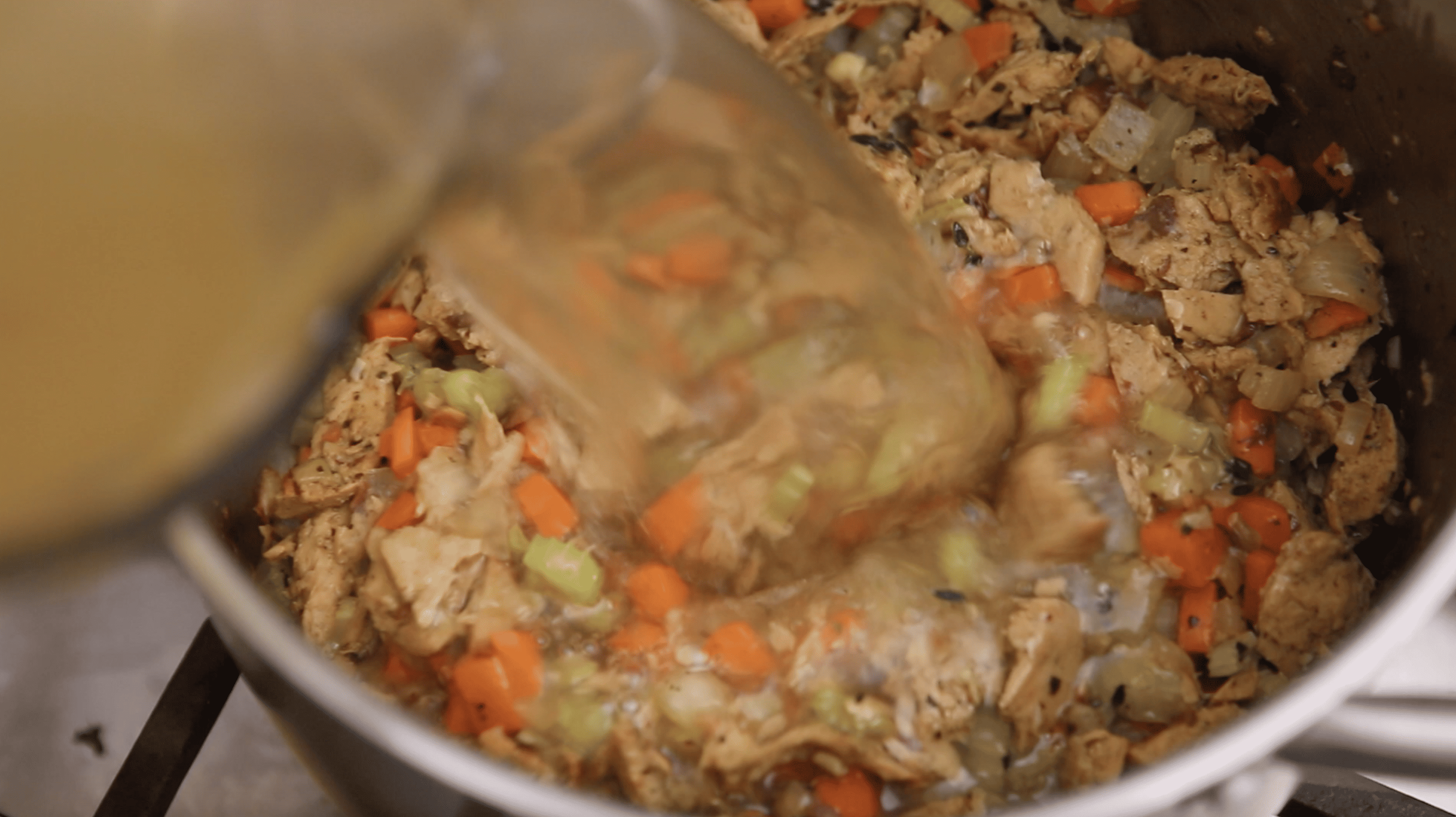 vegetable stock being poured into a pot