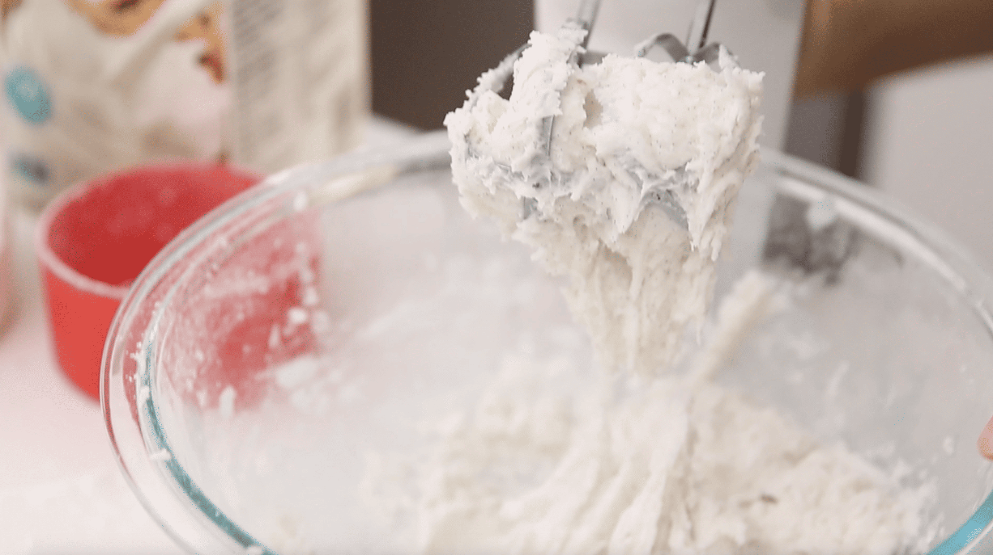 hand mixer showing texture of vanilla buttercream in a mixing bowl