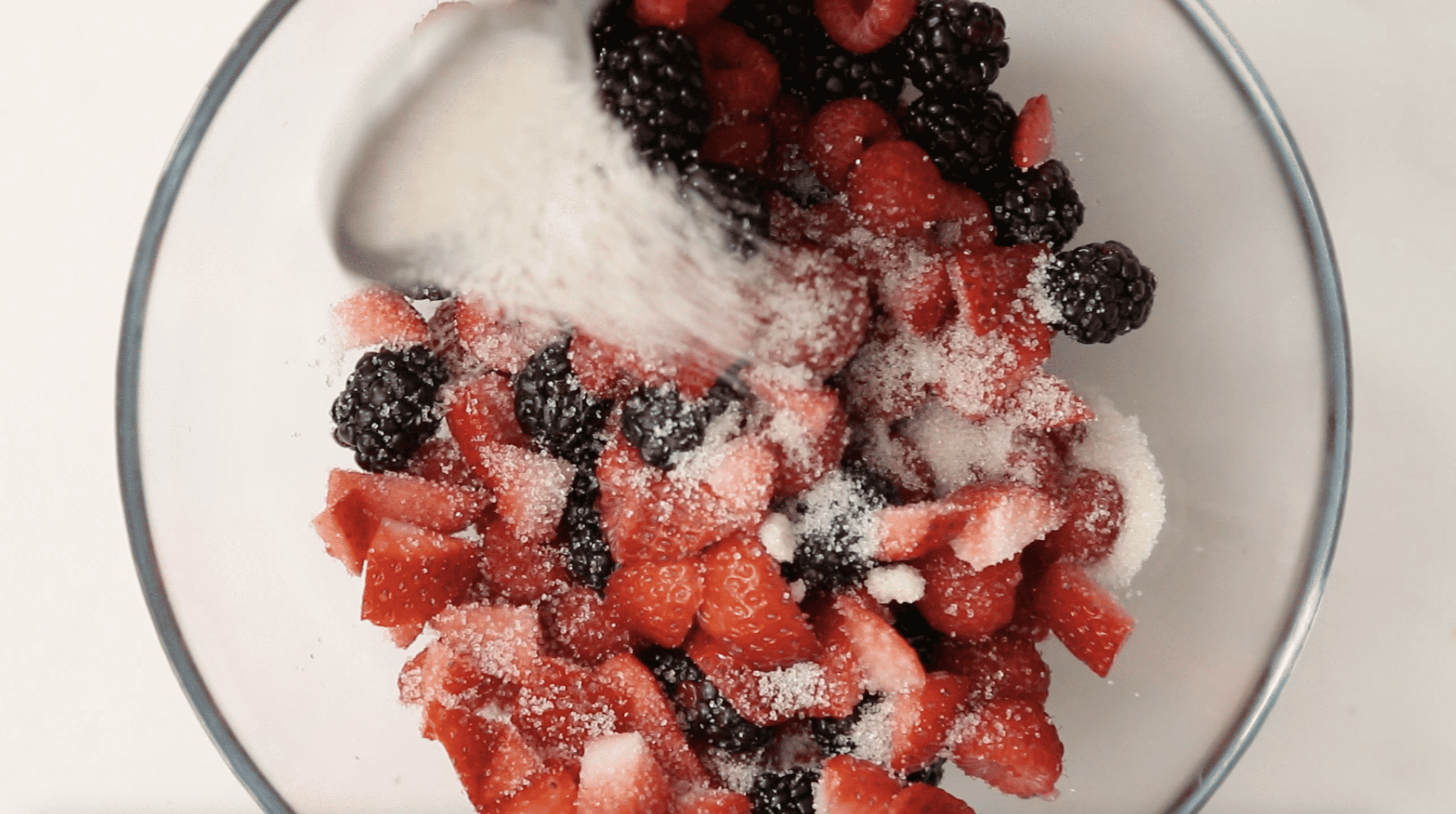 mixed berries in a bowl with sugar