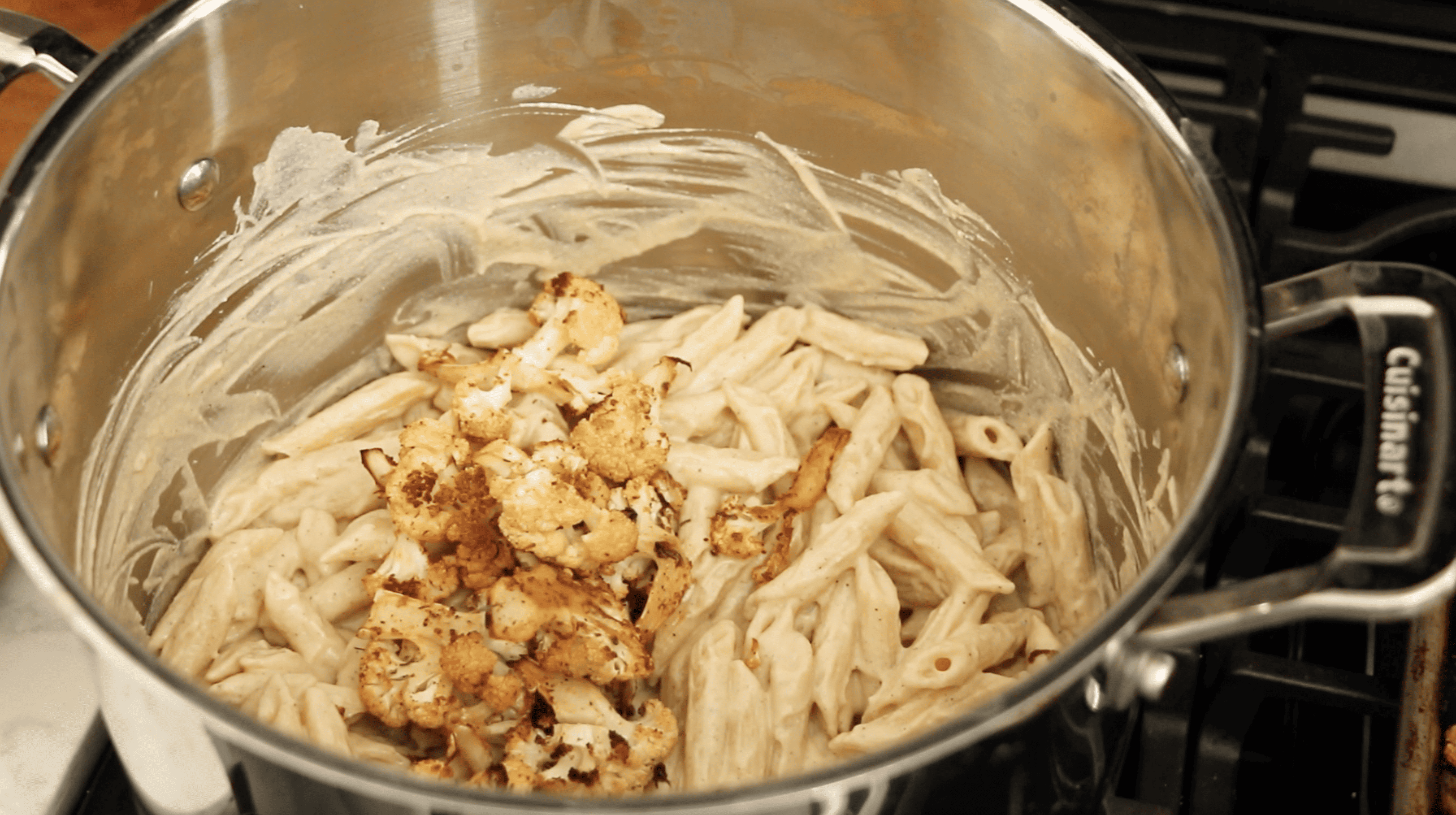 roasted cauliflower florets in a pot with alfredo penne
