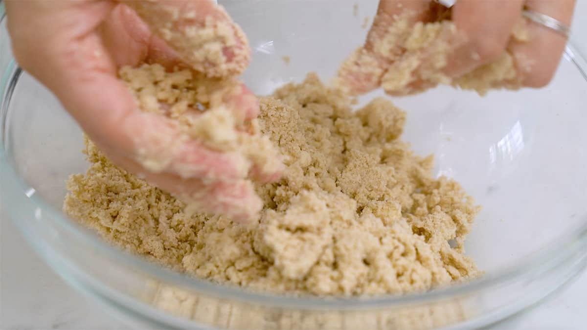mixing bowl with flour and butter being pinched together 