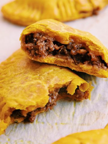 close up of jamaican patty broken in half revealing the filling