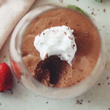 overhead of a serving of vegan chocolate mousse showing the texture with a spoon scoop taken out
